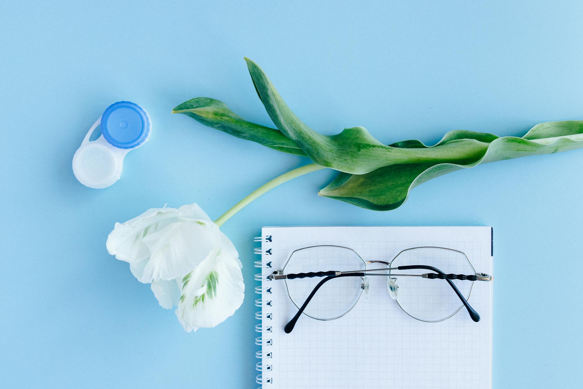 silver framed eyeglasses on white notebook