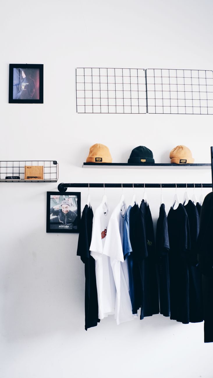 minimalist wardrobe with clothing and hats displayed